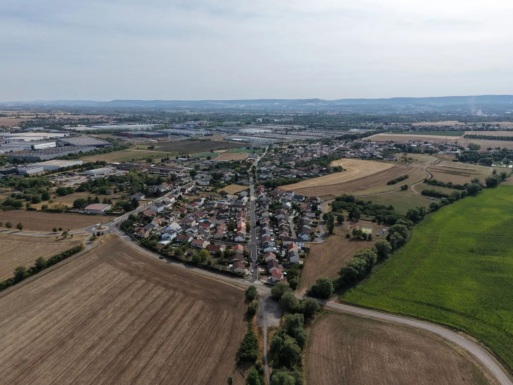 Drone aerial view of a river bend near a small village and farmland