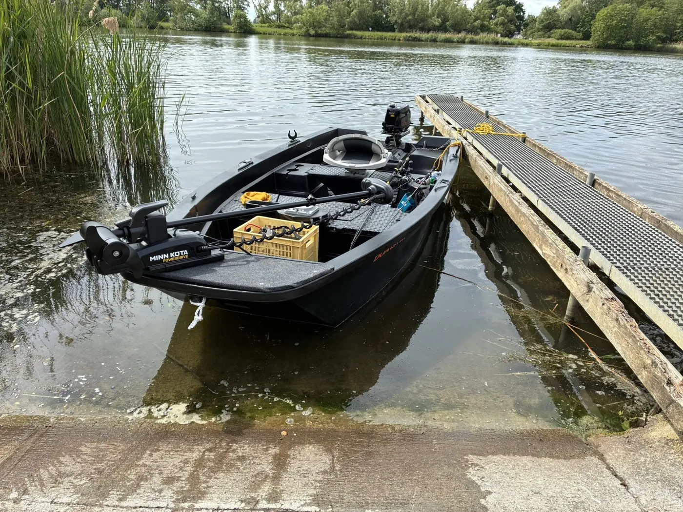 A small fishing boat moored at a quiet riverside dock
